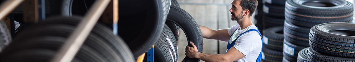 Mechanic picking up a tyre from stock - Tyres St Albans